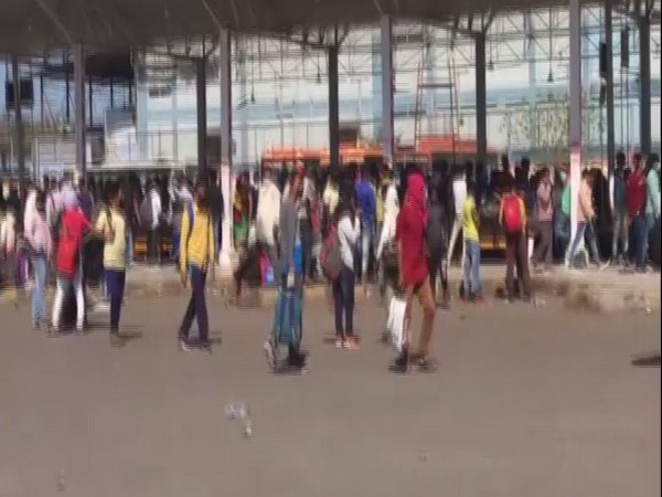 People waiting for their bus at the Kaushambi bus stand amid the lockdown. Photo/ANI