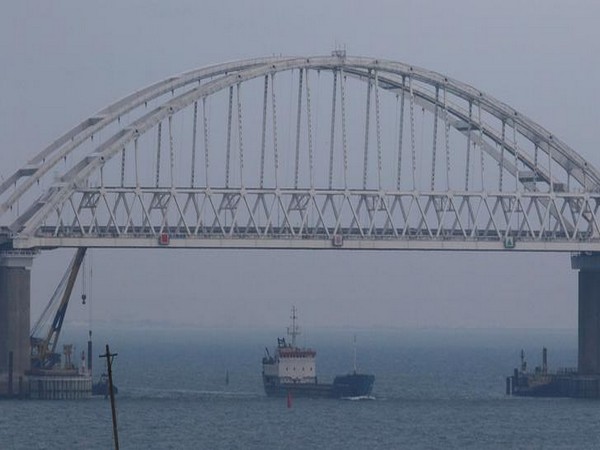 A vessel sails under a bridge connecting the Russian mainland with the Crimean Peninsula across the Kerch Strait