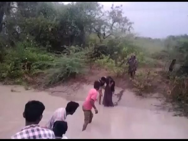 Locals rescuing girl, her grandmother in Karnataka's Koppal district on Sunday. (ANI/Photo)