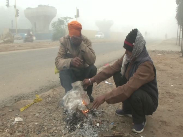 People warm their hands near fire in Ludhiana (Photo ANI)