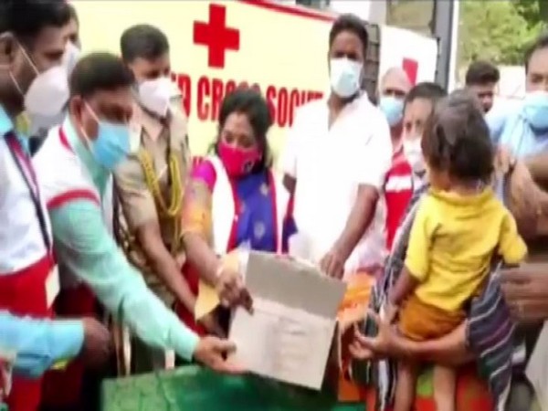Lieutenant Governor of Puducherry Dr Tamilisai Soundararajan distributes flood relief material at Karuvadikuppam. (Photo/ ANI) 