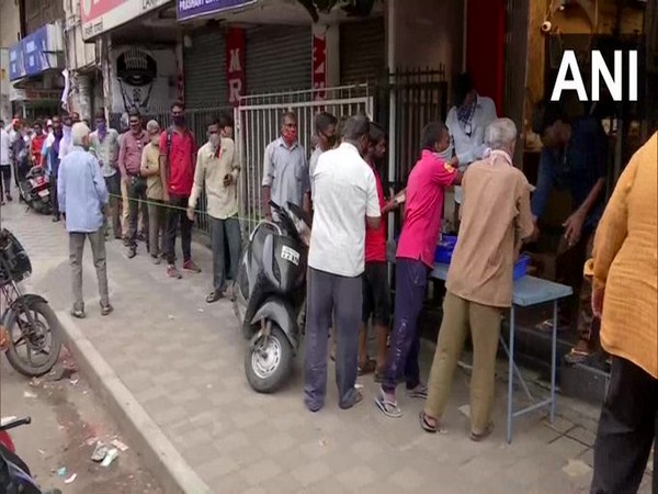 People gather outside liquor shops after lockdown announcement in Pune on Friday. Photo/ANI