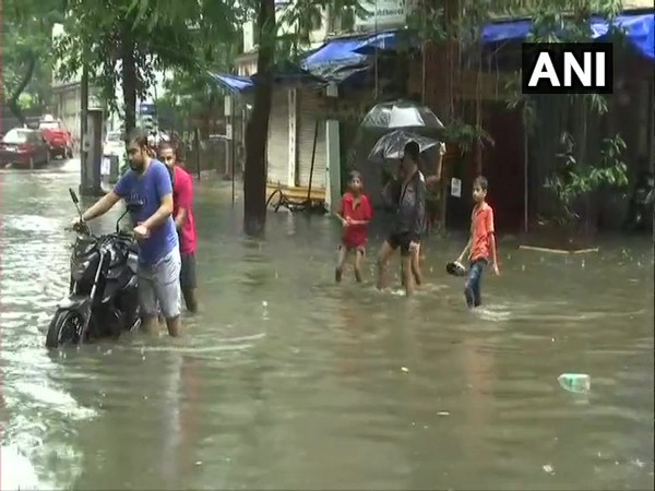 People negotiate knee-deep water in Mumbai