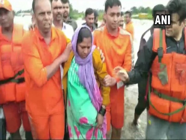 NDRF team along with the pregnant lady rescued in Kolhapur, Maharashtra on Saturday (Photo/ANI)