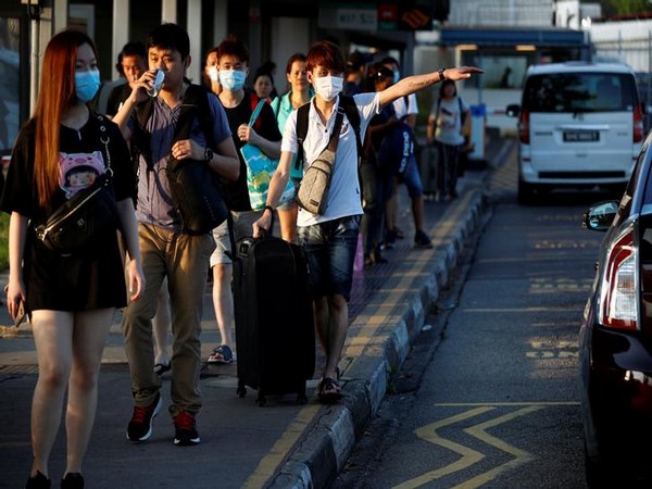 Commuters leave the Woodlands Causeway across to Singapore from Johor, hours before Malaysia imposes a lockdown on travel due to the coronavirus outbreak