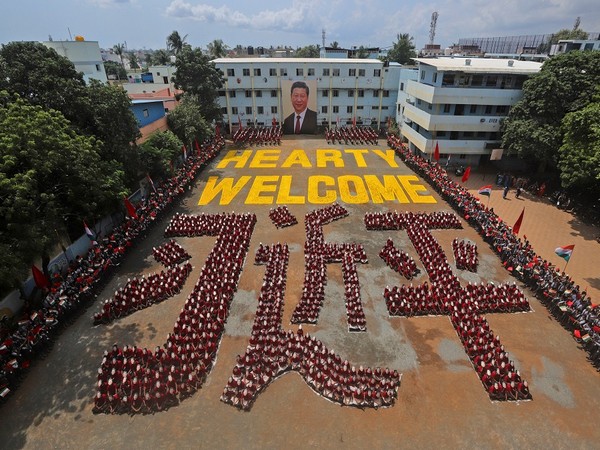 Students wearing masks of China's President Xi Jinping sit in a formation that reads 