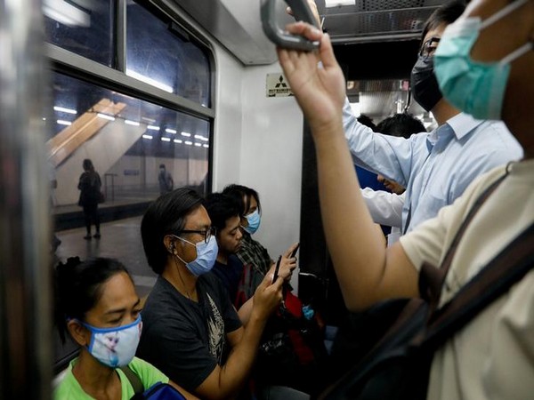Passengers wear protective masks inside a crowded train following new cases of coronavirus in Manila