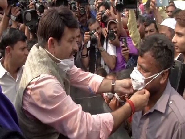 Delhi BJP president Manoj Tiwari distributing masks on Sunday in New Delhi. Photo/ANI