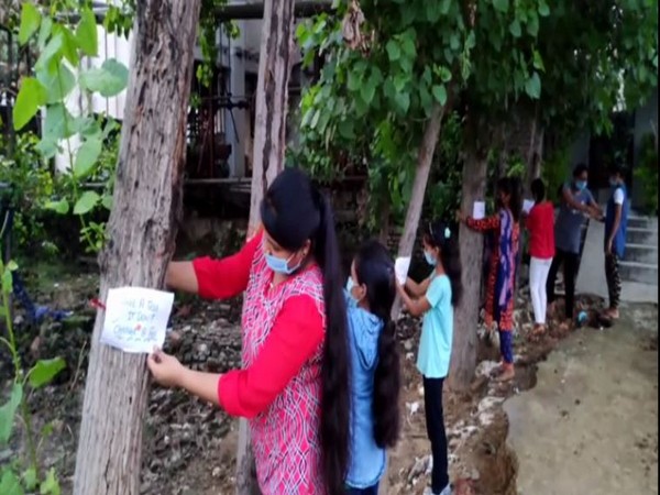 Students tying rakhis on trees with 'Save Environment' messages in Moradabad, Uttar Pradesh on Monday. (Photo/ANI)