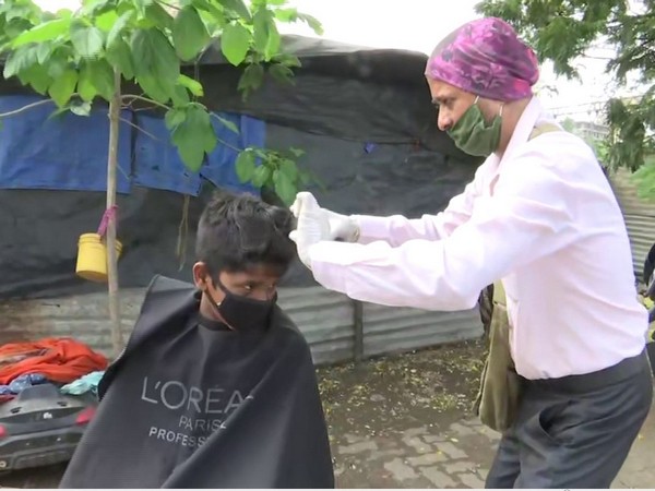 Hairdresser giving hair cut to children in Mumbai