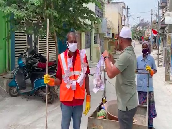 Municipal sanitary workers being felicitated by residents (photo/ANI)