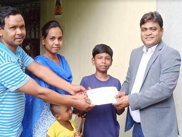 Mr. Ujjwal Sinha - Divisional Manager, Sany Heavy Industry India Pvt. Ltd. presenting the Demand draft to Joy Anugrah Kerketta, son of Mr..Kuldip Kerketta standing along with his wife and daughter. 