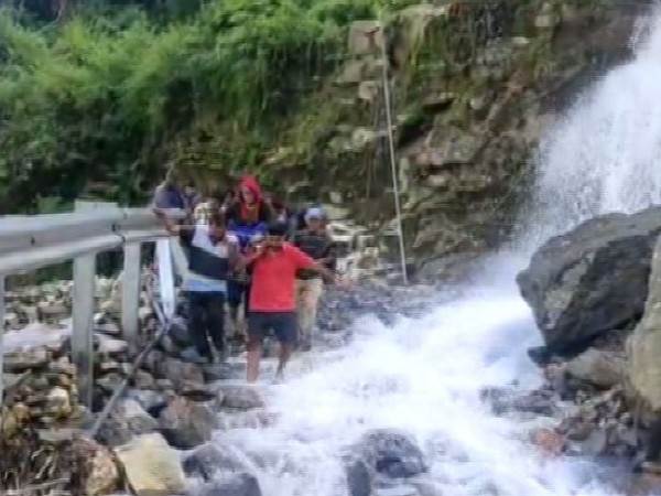 Elderly woman being carried on a makeshift stretcher to hospital in Uttarakhand on Monday. [Photo/ANI]