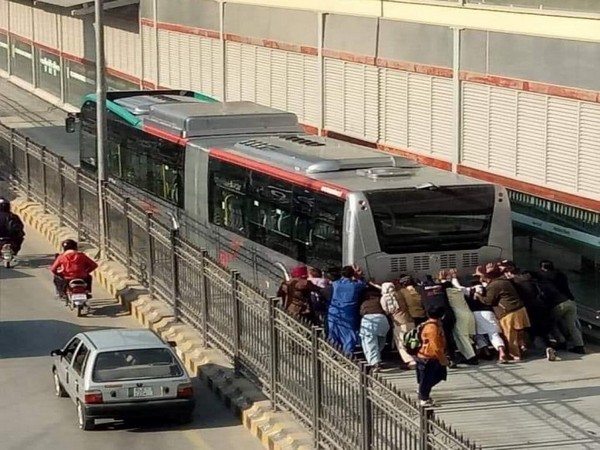 Passengers pushing the BRT bus that broke down in Peshawar.