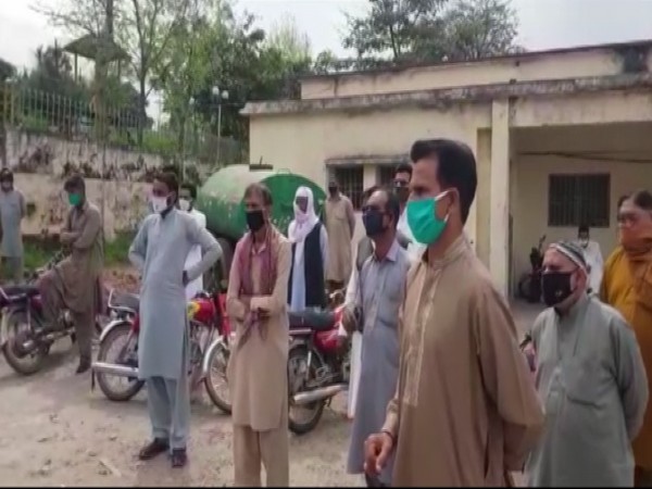 People in Mirpur, PoK, wait in a large group for the supply of essential items which are rather sold to the retail stores by Pakistani authorities  