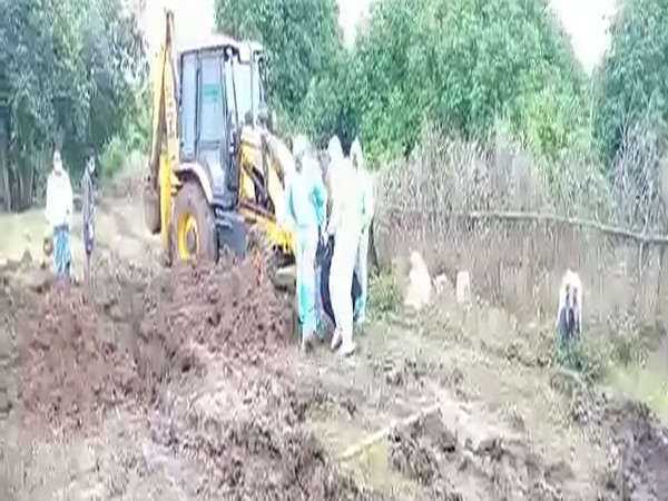 Avanigadda Sub-Inspector Sandeep along with others perform final rites of a COVID deceased on Tuesday. (Photo/ANI)