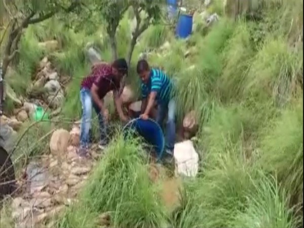 Officers of Excise and Special Enforcement Bureau police destroying country liquor in Kakarla forest area (Photo/ANI)