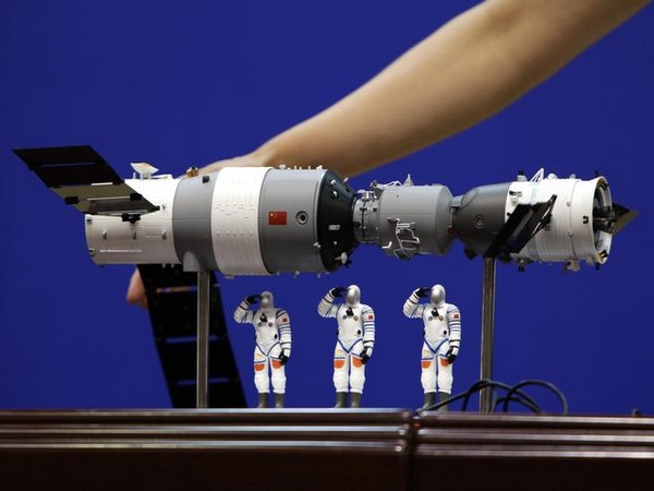 A model of the Shenzhou-9 manned spacecraft ( R) docking with the orbiting Tiangong-1 space lab module 