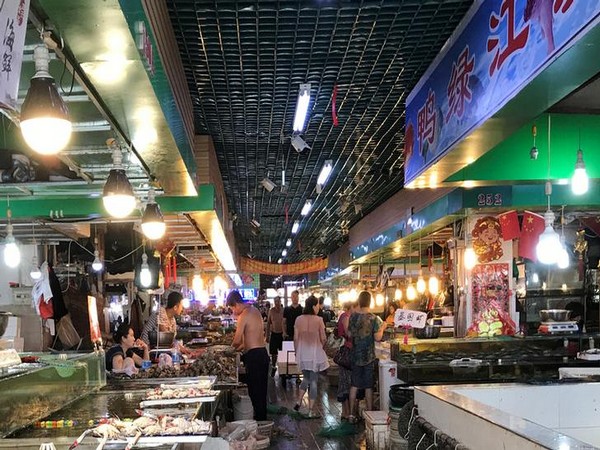 Customers select seafood at a wet market in Dandong, Liaoning province, China, August 8, 2017. 