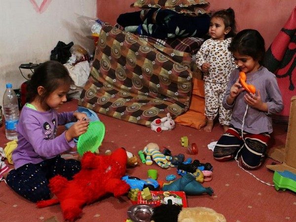 Syrian refugee kids play with toys inside a room at a makeshift Syrian refugee camp in the Lebanese border town of Arsal, Lebanon