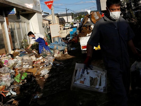 Locals clean a house, in the aftermath of Typhoon Hagibis, in Yanagawamachi district in Japan. Photo/ANI