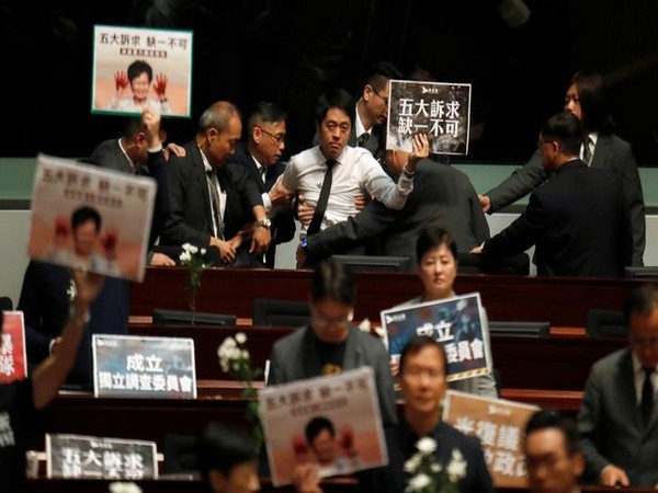 A pro-democracy lawmaker being escorted by security from the Hong Kong Legislative Council on Thursday. Photo/ANI