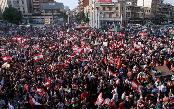 Demonstrators carry national flags during an anti-government protest in Tripoli, Lebanon