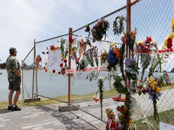 A man looks at a memorial at the harbour in Whakatane, following the White Island volcano eruption in New Zealand,