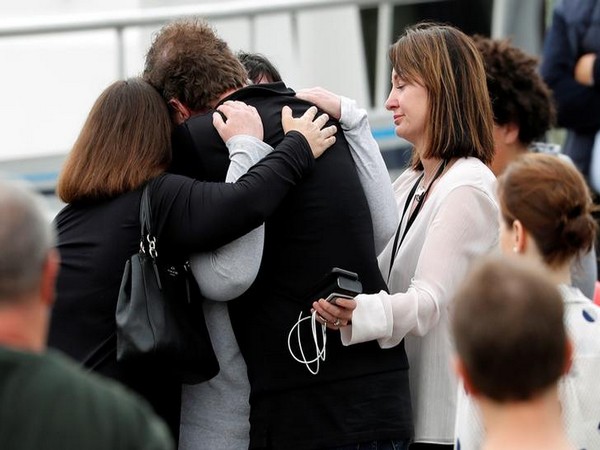 Relatives hug eachother as they wait for rescue mission following the White Island volcano eruption in Whakatane, New Zealand