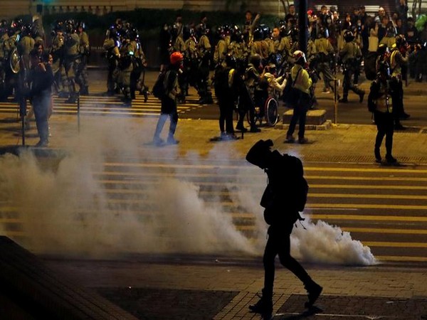 An anti-government demonstrator walks past tear gas on Christmas Eve in Hong Kong on Tuesday. Photo/Reuters