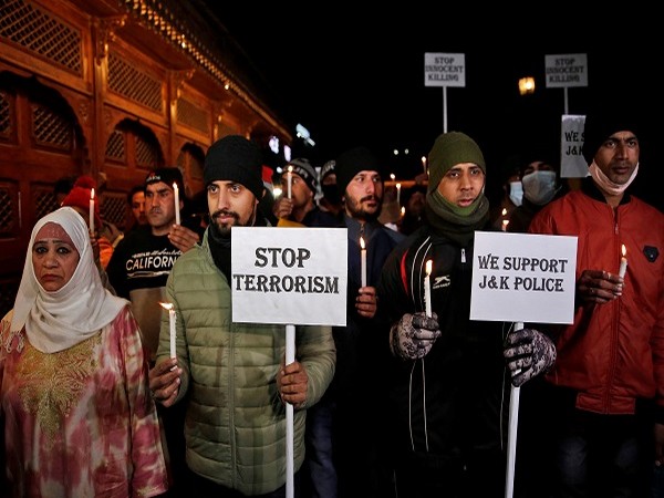 People hold a vigil to pay tribute to Indian police personnel who were killed after a bus carrying them was attacked by terrorists on Monday, in Srinagar December 14, 2021. (Photo Credit: Reuters)