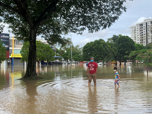 A man and his child stand in flood water in Shah Alam, Selangor state, Malaysia, December 19. (Photo Credit: REUTERS)