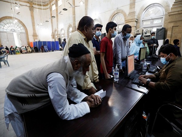 People gather to get themselves registered for coronavirus disease (COVID-19) vaccine at a vaccination centre in Karachi, Pakistan, (Photo Credit: REUTERS)