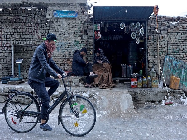 An Afghan man rides his cycle past a shop selling fuel in Kabul, Afghanistan, on January 27, 2022. (Photo Credit: REUTERS)