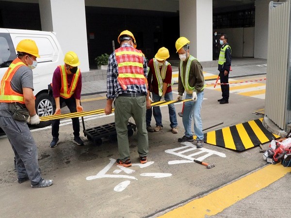 Construction workers cover with a metal plate parts of a painted slogan commemorating the 1989 Tiananmen Square crackdown in Hong Kong. (Photo Credit: REUTERS)