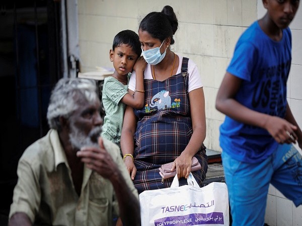 A pregnant woman and her son wait in a queue to buy kerosene at a fuel station, amid the country's economic crisis in Colombo. (Photo Credit: Reuters)