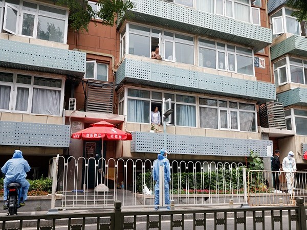Residents look on from their windows in a residential building under lockdown, amid the coronavirus disease (COVID-19) outbreak in Beijing. (Photo Credit: Reuters)