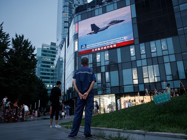 A man watches a CCTV news broadcast, showing a fighter jet during joint military operations near Taiwan by the Chinese's PLA, at a shopping center in Beijing. (Photo Credit: REUTERS)