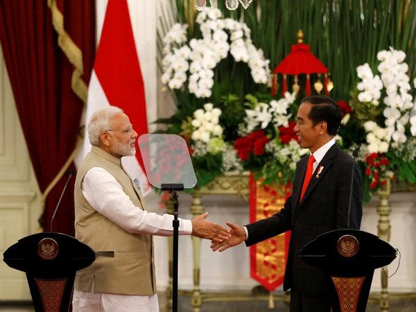 Indian Prime Minister Narendra Modi (L) shakes hands with Indonesia President Joko Widodo after they spoke following their meeting at the presidential palace in Jakarta