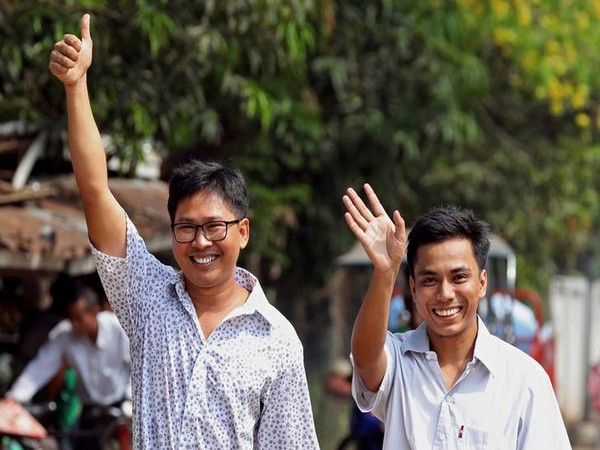 Reuters reporters Wa Lone and Kyaw Soe Oo gesture as they walk to Insein prison gate after being freed in Yangon, on Tuesday (Reuters)
