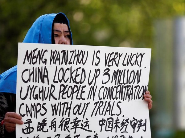 A demonstrator holds a sign protesting China's treatment of Uighur people in the Xinjiang region (Photo: Reuters)