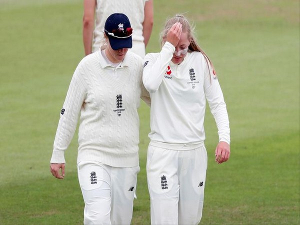 England's Anya Shrubsole (left) taking teammate Sophie Ecclestone (right) off the field after the latter injured her right shoulder