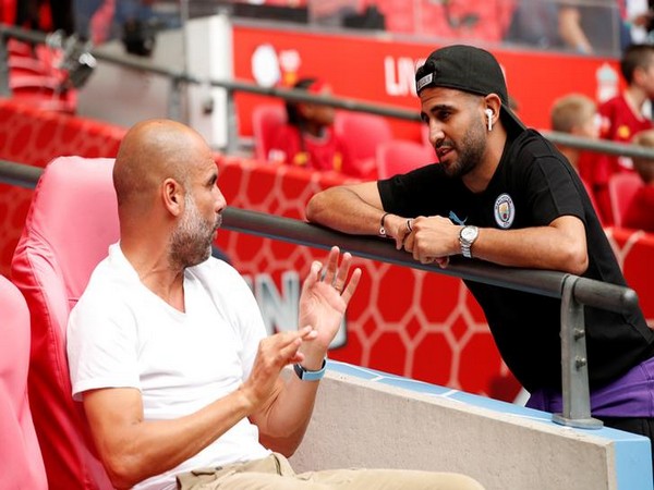 Manchester City manager Pep Guardiola (left) with Riyad Mahrez (right)