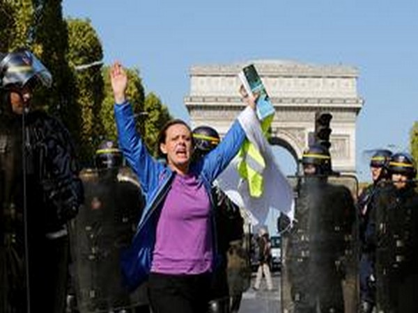 A protester holds her hands up as she takes part in a demonstration as part of the yellow vests movement in Paris, France