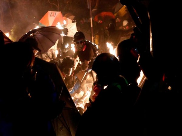 Anti-government protesters take cover during a standoff with riot police at the Chinese University of Hong Kong.