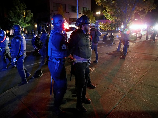 Police officers detain a demonstrator during a protest against police violence and racial injustice in Portland