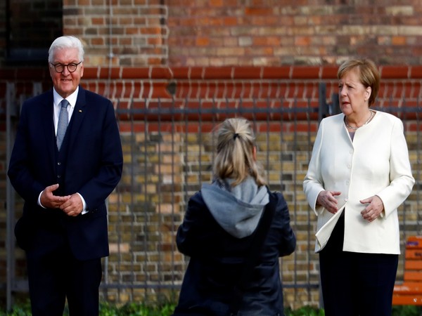 German President Frank-Walter Steinmeier and Chancellor Angela Merkel pose before the start of the festivities to mark the 30th anniversary of the German reunification in Potsdam.