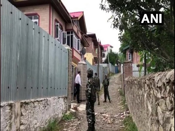 Security personnel outside a house raided by the NIA in Baramulla district on Sunday.