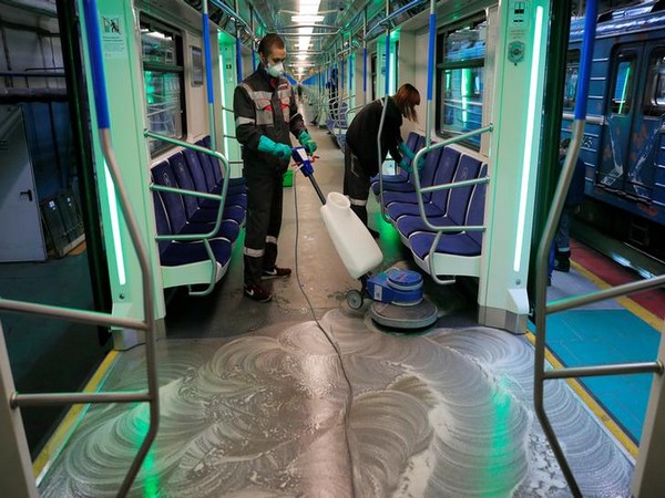 Employees wearing protective face masks clean and disinfect a subway train, as part of measures to prevent the spread of coronavirus in Moscow