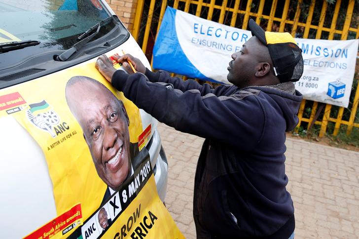 A man places an election poster of President Cyril Ramaphosa on a minibus taxi outside a polling station on Wednesday in Johannesburg, South Africa. (Photo: Reuters)